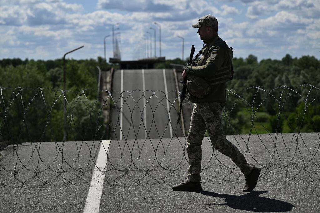 Een Oekraïense grenswacht bij een verwoeste grensovergang tussen Oekraïne en Belarus, in de regio Tsjernihiv. Foto: Genya Savilov / ANP / AFP